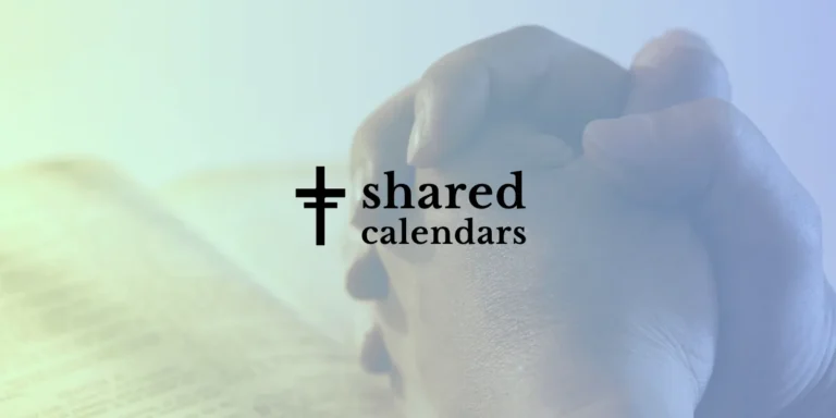 Hands clasped in prayer over book